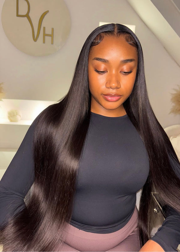 Woman with long, straight hair in a salon setting with a visible brand logo.