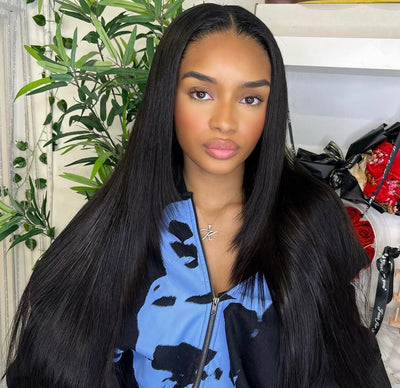 Woman with long black hair wearing a blue and black patterned jacket indoors.